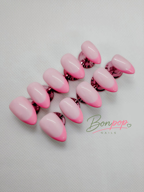 A set of artificial press-on nails with a glossy pink ombre gradient, transitioning from light pink to vibrant hot pink, displayed on a textured white background with a 'Bonpop Nails' logo watermark.